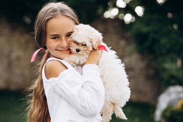 Cute girl hugging her maltipa dog