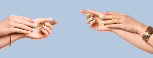 Hands of young woman with beautiful manicure on color background