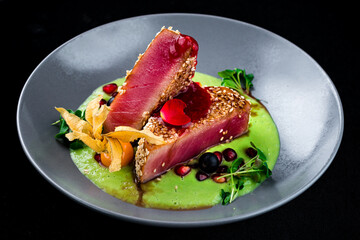 Seared tuna with sesame, physalis, cranberry, pomegranate, sauce and microgreens.