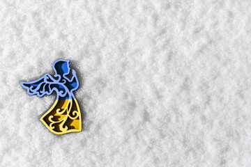 blue and yellow toy angel on white snow