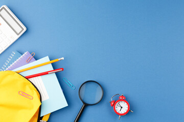 School backpack with stationery on the desk.