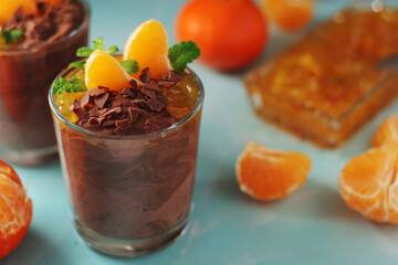 Chocolate mousse dessert with tangerines in glasses