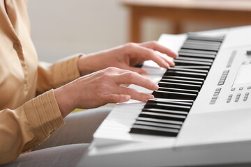 Fototapeta premium Mature female musician playing synthesizer, closeup
