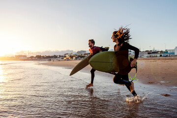 Surfers running to the waves in ocean.