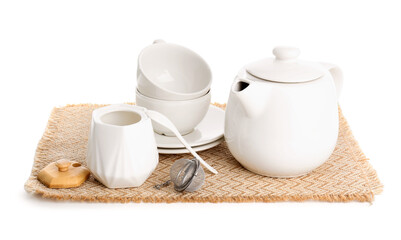 Wicker mat with teapot, sugar bowl and cups isolated on white background