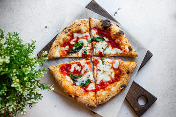 Neapolitan pizza Margarita with tomato sauce, mozzarella and basil cooked in the stone oven on a white background - obrazy, fototapety, plakaty