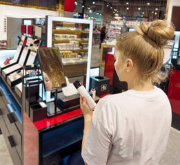 buying make up at cosmetics section in store. choosing cosmetics, perfumes, creams and shampoos, Using tester.
