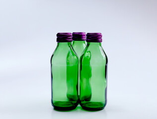 Set of green Glass bottles with purple cap. Isolated on white background.