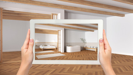 Augmented reality concept. Hand holding tablet with AR application used to simulate furniture and design products in empty wooden interior, minimal bedroom and bathroom