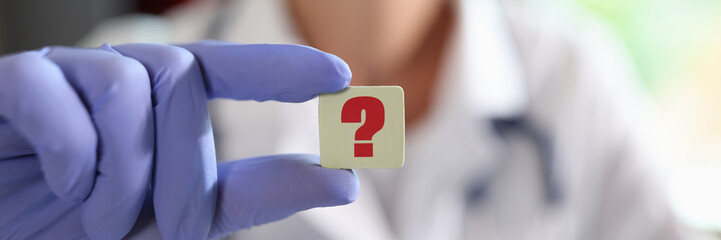 Question mark in hand of general practitioner or cardiologist in clinic