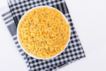 Uncooked Chifferi Rigati Pasta in White Cup on Black Checkered Towel. Fat and Unhealthy Food. Classic Dry Macaroni. Italian Culture and Cuisine. Raw Pasta