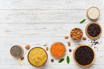 Various superfoods in smal bowl on colored background. Superfood as rice, chia, quinoa, lentils, nuts, sesame seeds, almonds. top view copy space