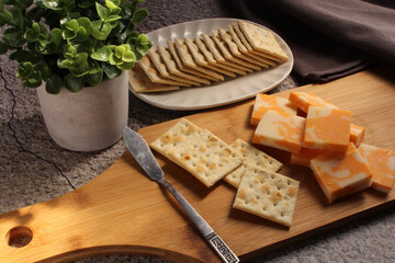Cheese and crackers on a wooden breadboard