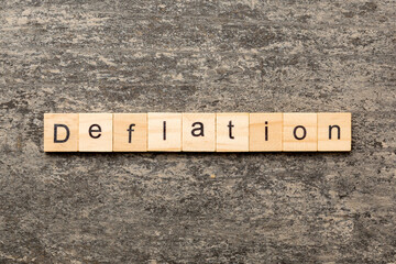 deflation word written on wood block. deflation text on table, concept