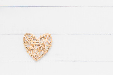 Wooden wicker heart on white table background with copy space for love and Valentine's day concept