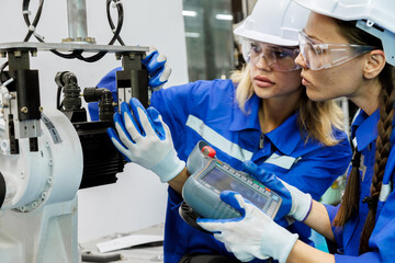 female automation machine engineer student study and inspection control robot arm machine in university or factory workshop. ai robot technology new innovation trend of manufacturing in industry 5.0
