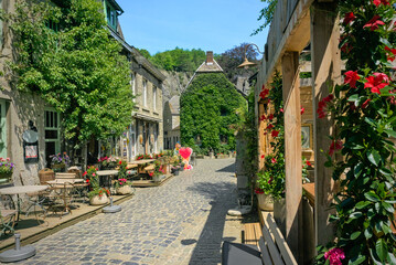 A narrow cobblestone street in Durbuy, the smallest city in Belgium, surrounded by historical stone...