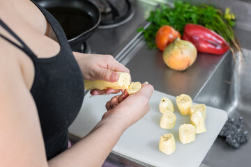 detailed view from above of the hands of a woman breaking a banana into pieces to make patacones