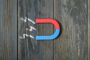 Magnets with drawn lightnings on dark wooden background