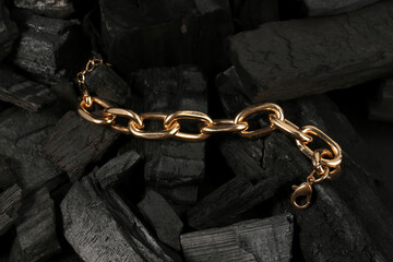 Beautiful chain bracelet on black charcoal, closeup