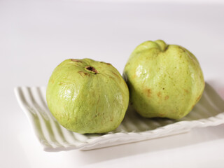 Crystal Guava (Psidium guajava) or Jambu Kristal, served in white ceramic square plate isolated in white background, copy space.