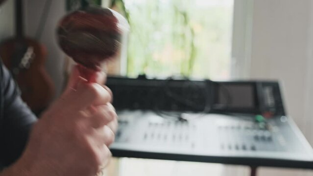Man hands with maracas playing mexican traditional music indoors. Musician with latin hispanic musical instrument making perfomance