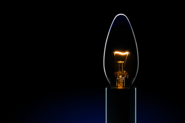 Light bulb with  tungsten filament burning in dark