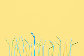 Different plastic drinking straws on beige background