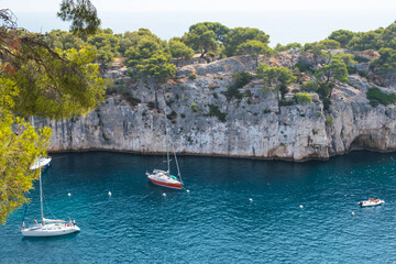 Naklejka na ściany i meble Beautiful seascape with smooth water surface and rocky cliffs in Calanques National Park. Popular travel destination in Southern France.