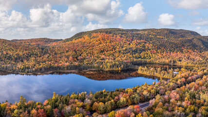 Maine  - New England fall foliage at a lake with sunset autumn colors 