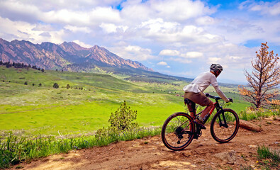 Fototapeta na wymiar Mountain biker on the Doudy Draw Trail near Boulder, Colorado, with the Flatirons in the background