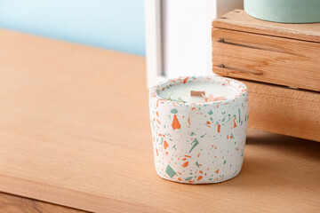 Holder with candle and decor on table in room, closeup