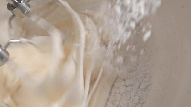 Pie dough kneading with automatic mixer closeup. Adding a flour and mixing with blender.