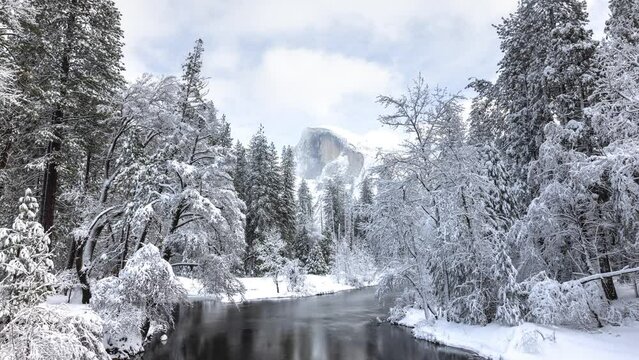 Time lapse of a snowy winter landscape in Yosemite National Park. Half Dome can be seen in the distance.
