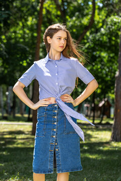 Young girl in a long denim skirt, summer park outdoors