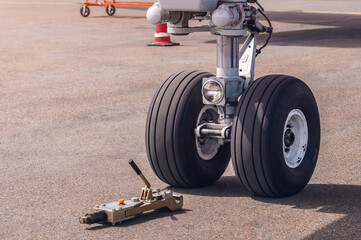 Airliner landing gear close-up. Main nose landing gear with two wheels, landing light and tow bar...