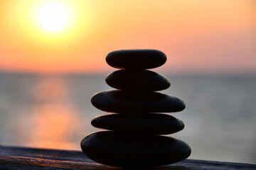 Relaxation Zen concept - cairn, stacked stones outside, blurred sunset sun nature background