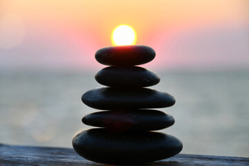 Relaxation Zen concept - cairn, stacked stones outside, blurred sunset sun nature background