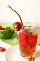 Glass of infused water with strawberry on table