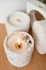 Holder with burning candle on table in room, closeup