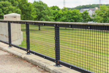 A metal fence on the streets symbolizing division, confinement, and societal boundaries,...