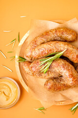 Plate with tasty homemade sausages on orange background