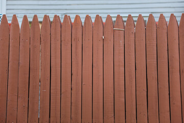 weathered wooden fence on the streets symbolizes boundaries, protection, and the passage of time, evoking a sense of security and nostalgia