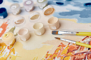 Close up of paints and brushes for coloring a picture by numbers.