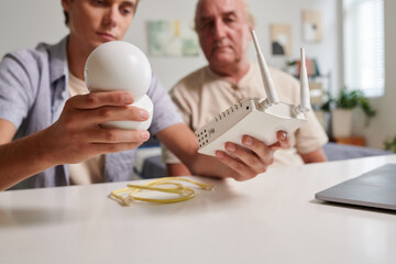 Grandson helping grandfather to install surveillance camera at home