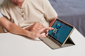 Son installing personal assistant on tablet computer of senior father