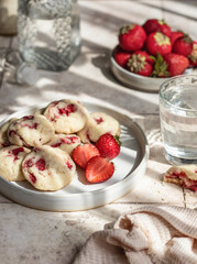 Homemade cookies with strawberries. Delicious summer pastries on pink tile background with clear shadows