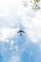Avión en el cielo azul con nubes desde abajo, avión de pasajeros de alto vuelo. 