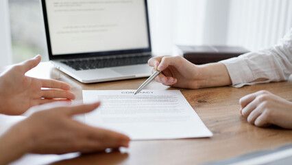 Business people discussing contract signing deal while sitting at the wooden table in office. Partners or lawyers working together at meeting. Teamwork, partnership, success concept