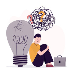 Unhappy businessman sits near an extinguished broken light bulb. Problem with creativity, lack of ideas. Brainstorming difficulties, emotional crisis, business burnout.